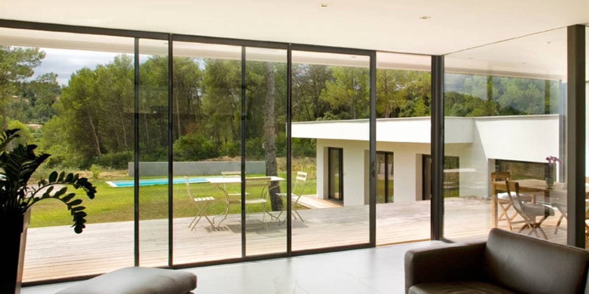Baie vitrée transparente avec vue sur le jardin et la terrasse
